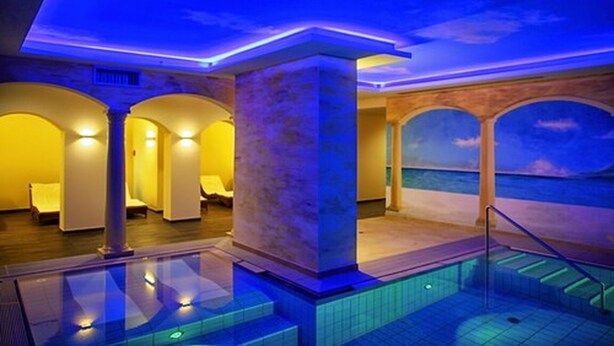 A pool area with a view of the sea, featuring a glass barrier, a marble column, and a sunset mural on the ceiling. - Kurpark-Hotel Bad Dürkheim (Bad Durkheim)
