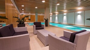 Un espace aménagé au bord de la piscine, avec des meubles en osier et un plafond en bois.