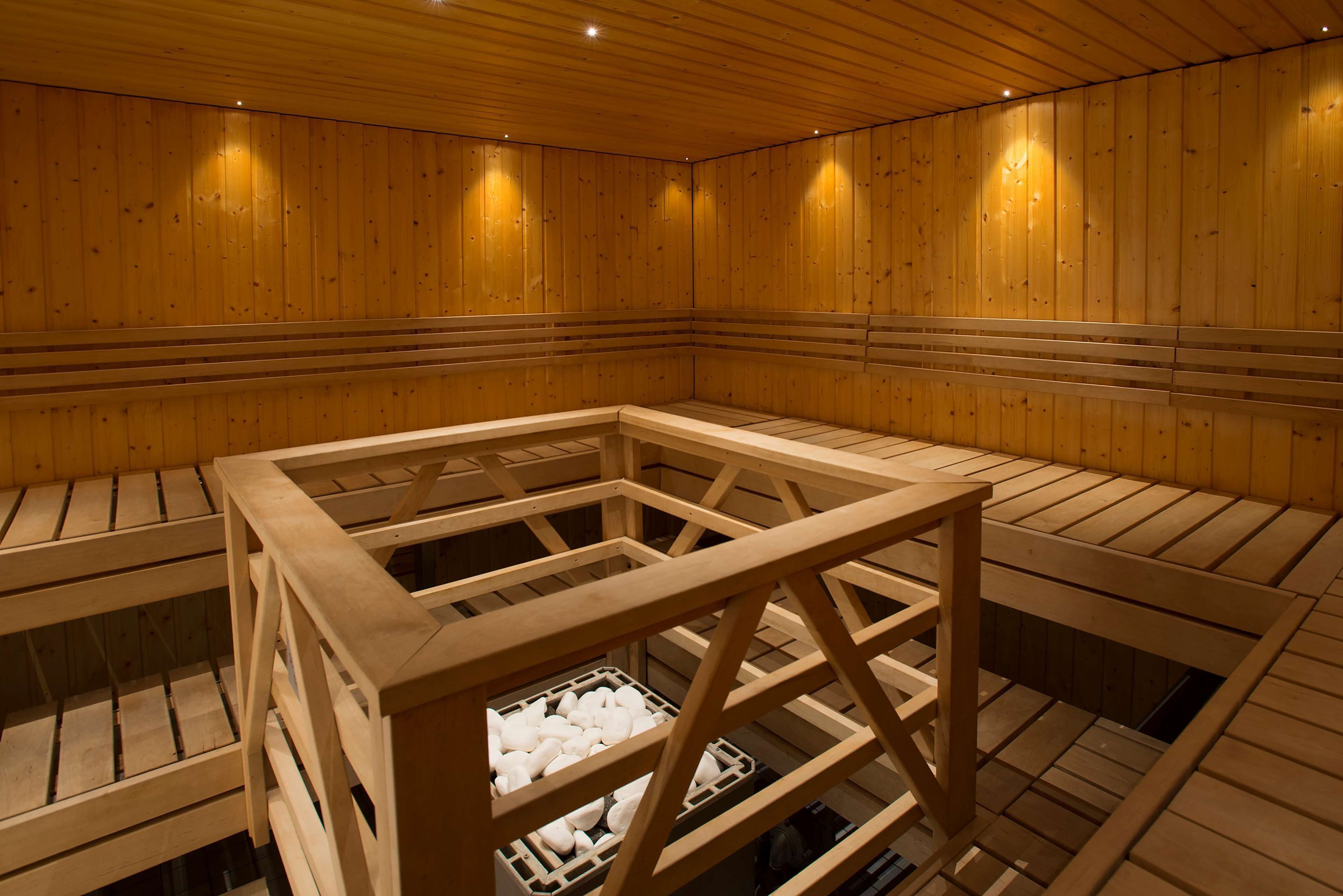 A sauna with wooden benches and a central wooden structure.