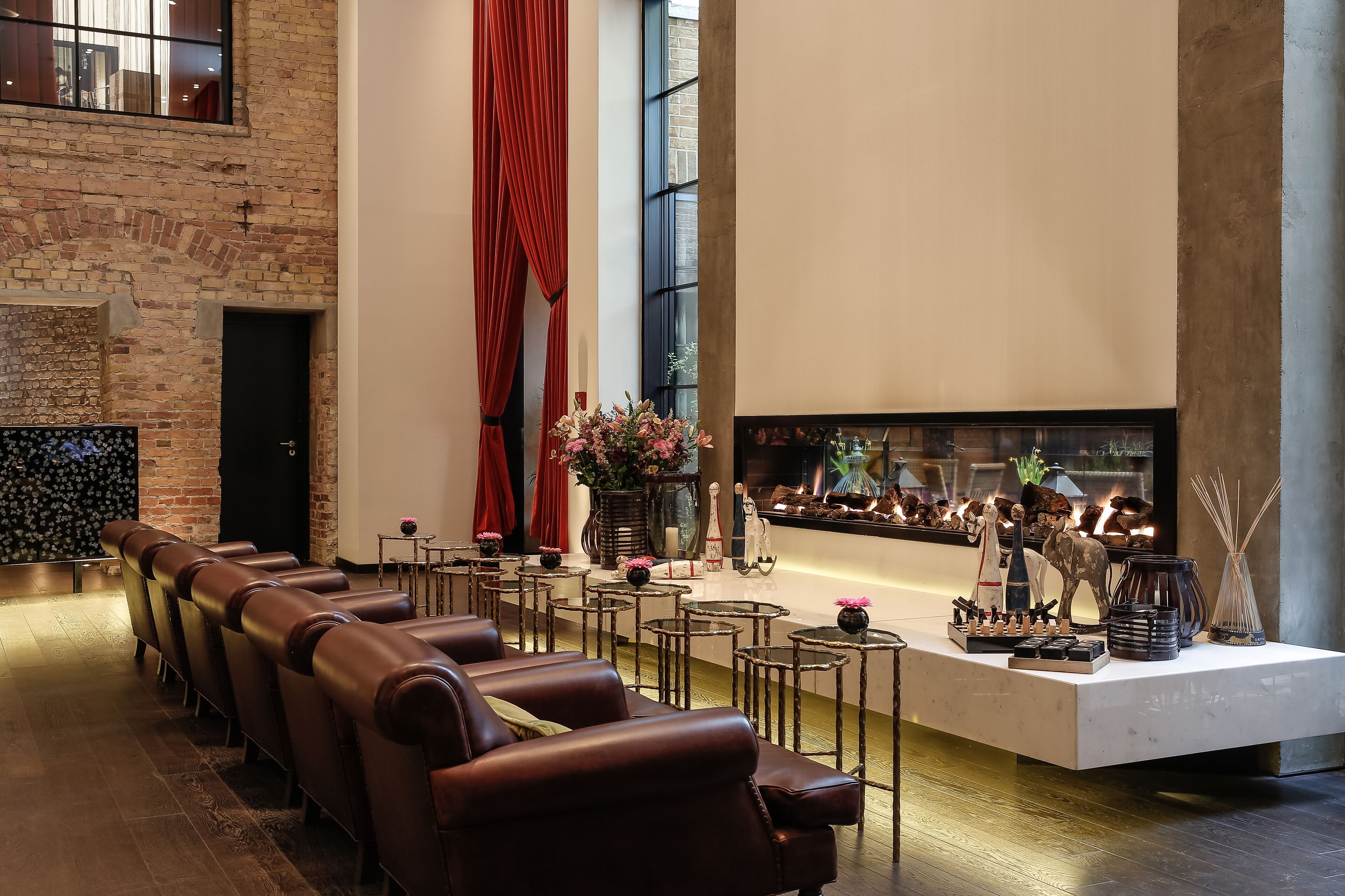 A modern lounge area with leather seating, a fireplace, and decorative items.