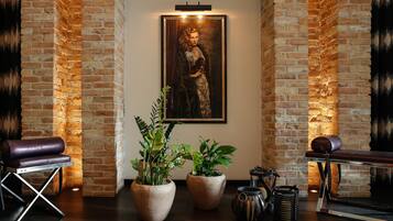 Relax in a stylish space with a brick accent wall, framed artwork, and lush greenery.