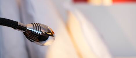 A close-up of a metallic object with a black cord, likely a part of a room's furniture or equipment.
