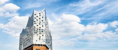 A modern building with a unique angular design, featuring a mix of glass and brick materials.