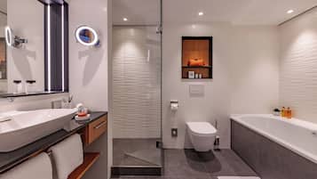 Ein modernes Badezimmer mit einem großen Waschbecken, einer Duschkabine, einer Toilette und einer Badewanne.