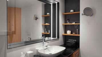 A modern bathroom with a large mirror, a white sink, and built-in shelves with toiletries.
