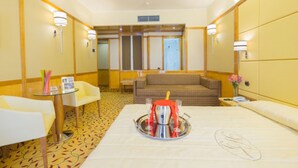 Une chambre d’hôtel avec un lit, une petite table avec un plateau, un canapé et une chaise.
