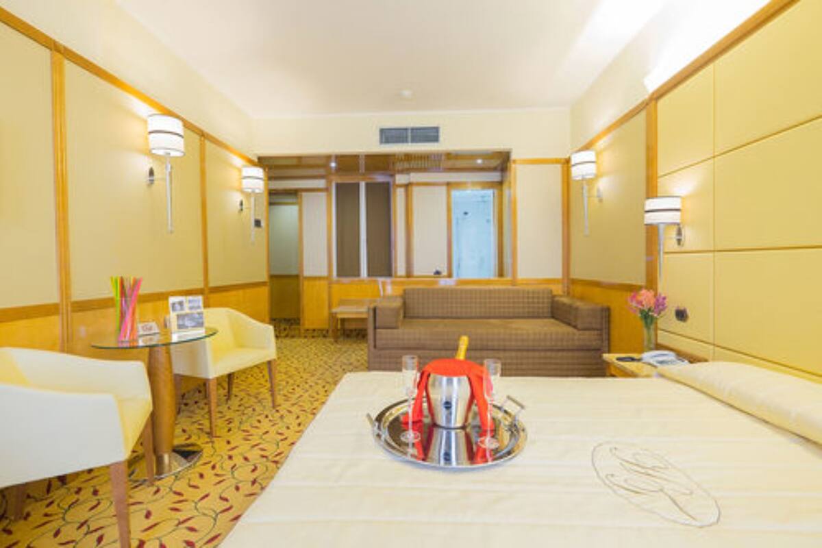 Une chambre d’hôtel avec un lit, une petite table avec un plateau, un canapé et une chaise.