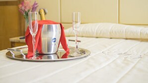 Un plateau de petit-déjeuner soigneusement préparé, avec une bouteille de champagne et deux verres, posé sur le lit.