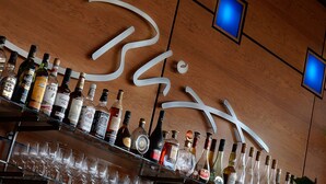 A bar area with various liquor bottles and glasses. - ATLANTIC Hotel Airport (Bremen)