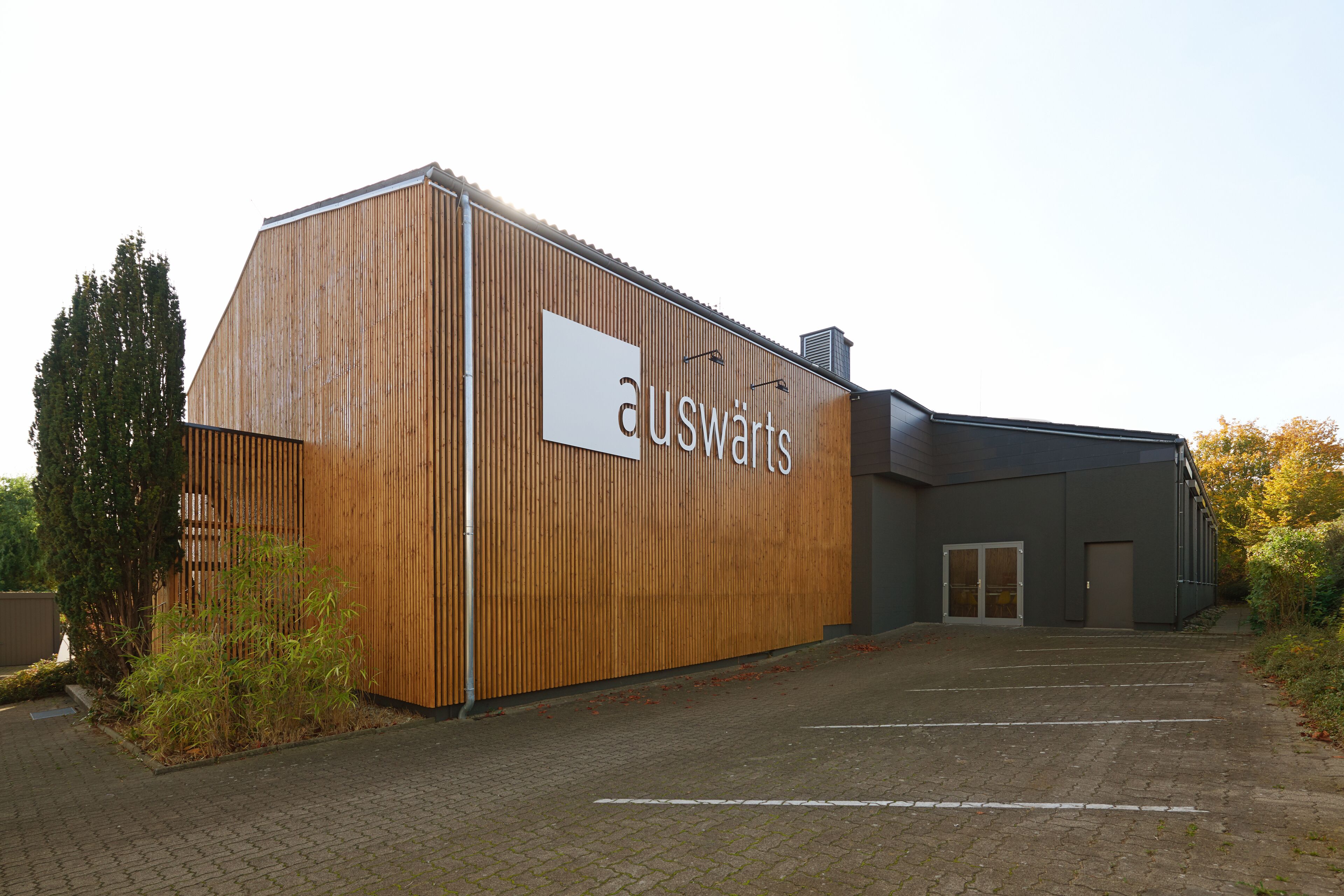 A building with a wooden facade and a sign that reads "auswäerts".