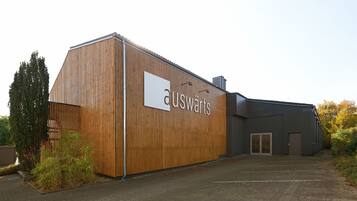 A building with a wooden facade and a sign that reads "auswäerts".