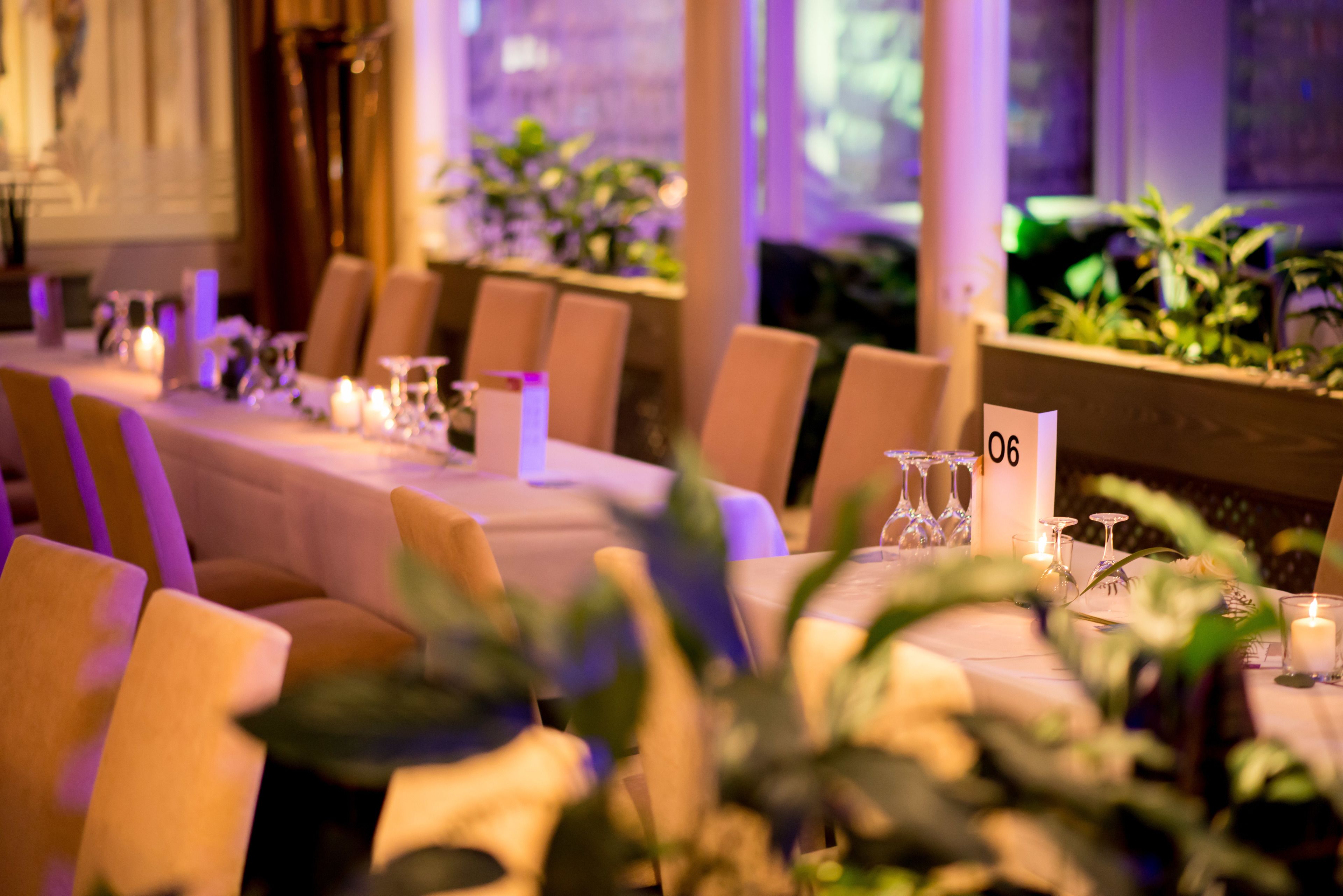 A long dining table with chairs, candles, and a number sign.