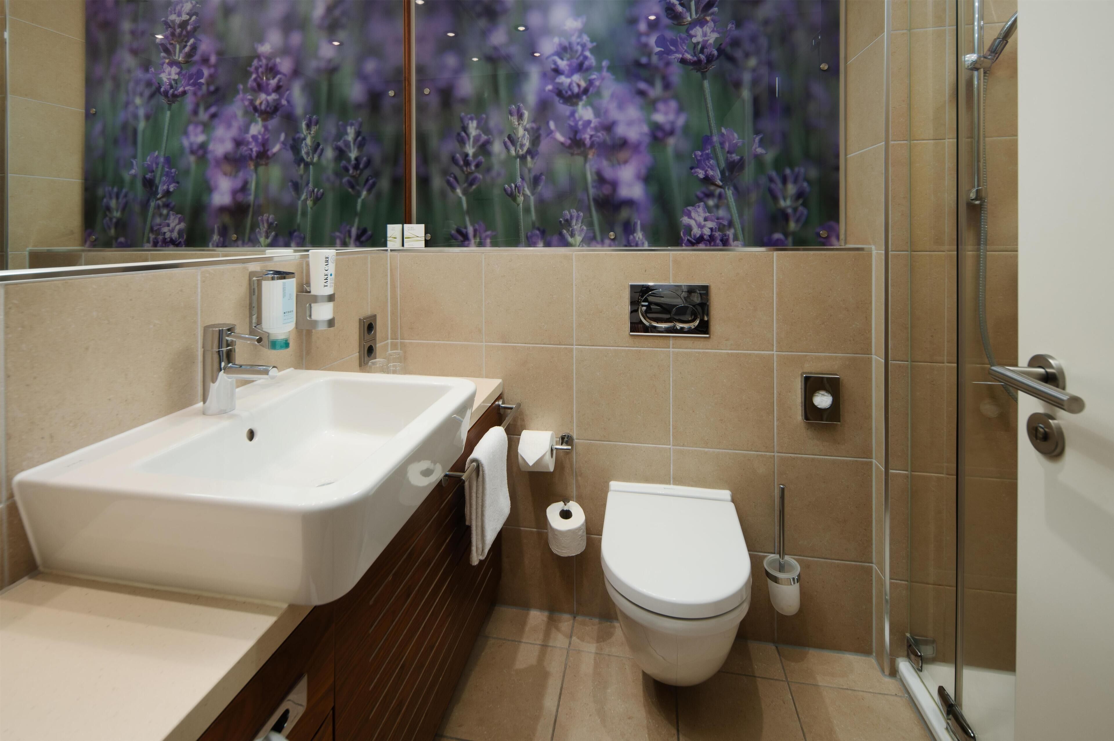 A bathroom with a sink, toilet, and shower.