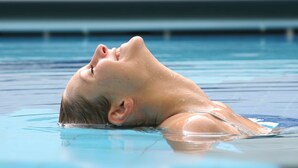 A person submerged in a swimming pool.