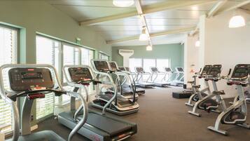 Un gimnasio con cintas de correr y equipo de ejercicio.