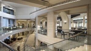 A multi-level hotel lobby with a central staircase, glass railings, and modern furnishings. - The David Citadel Jerusalem (Jerusalem)