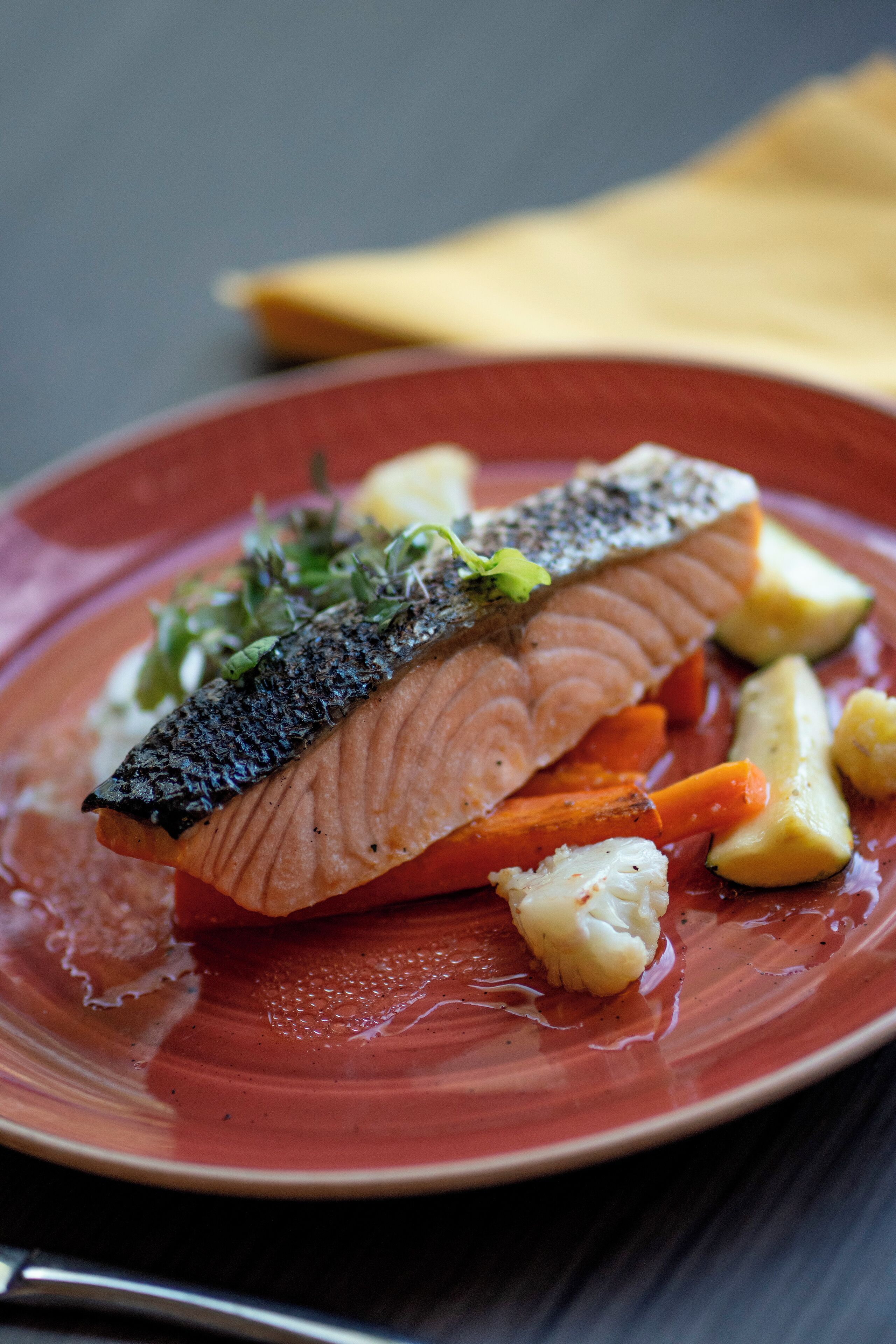A plate of cooked fish with vegetables.