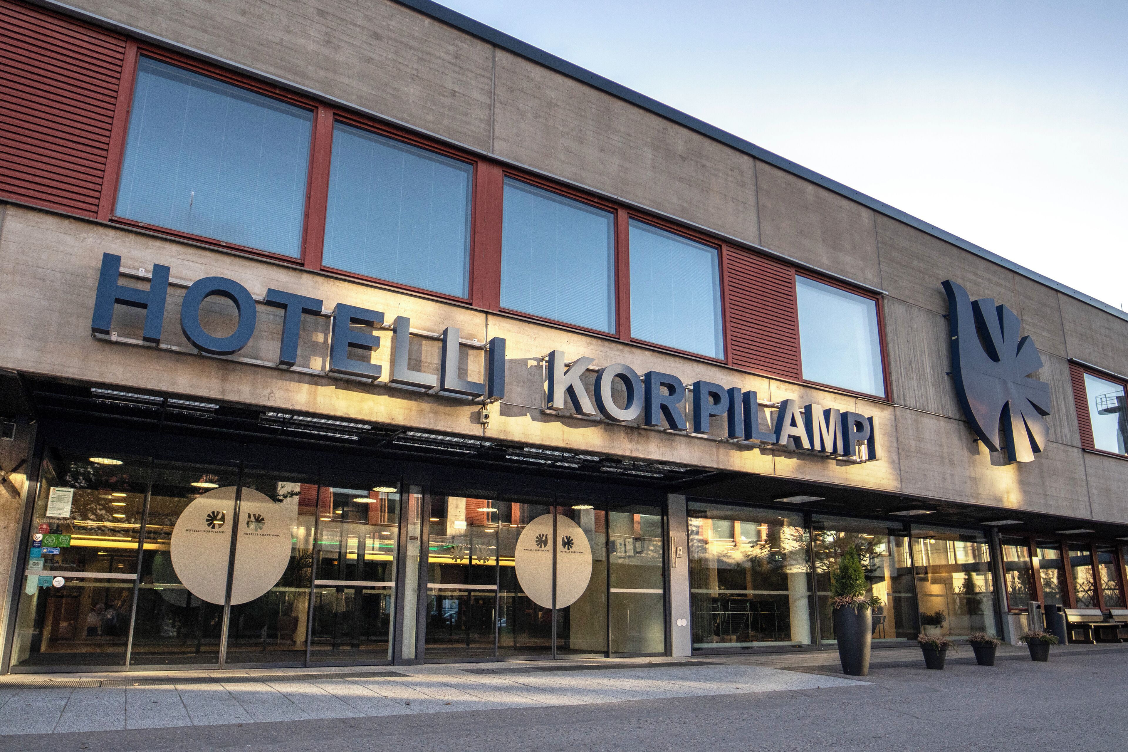 Un hotel con fachada moderna, ventanas amplias y un cartel llamativo.