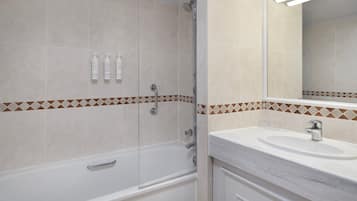 A bathroom with a bathtub, a sink, and a mirror.