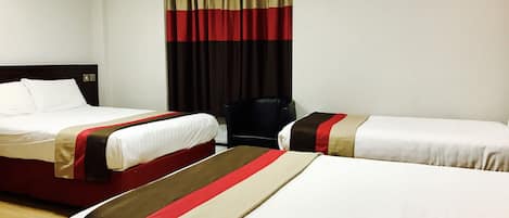 Quarto de hotel com duas camas, uma cadeira preta e uma cortina.