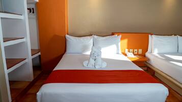 Relax in a cozy retreat with a neatly made bed, a white towel, and a unique cat-shaped towel on the headboard.