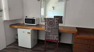 Une petite cuisine équipée d’un four à micro-ondes, d’un réfrigérateur et d’un petit congélateur.