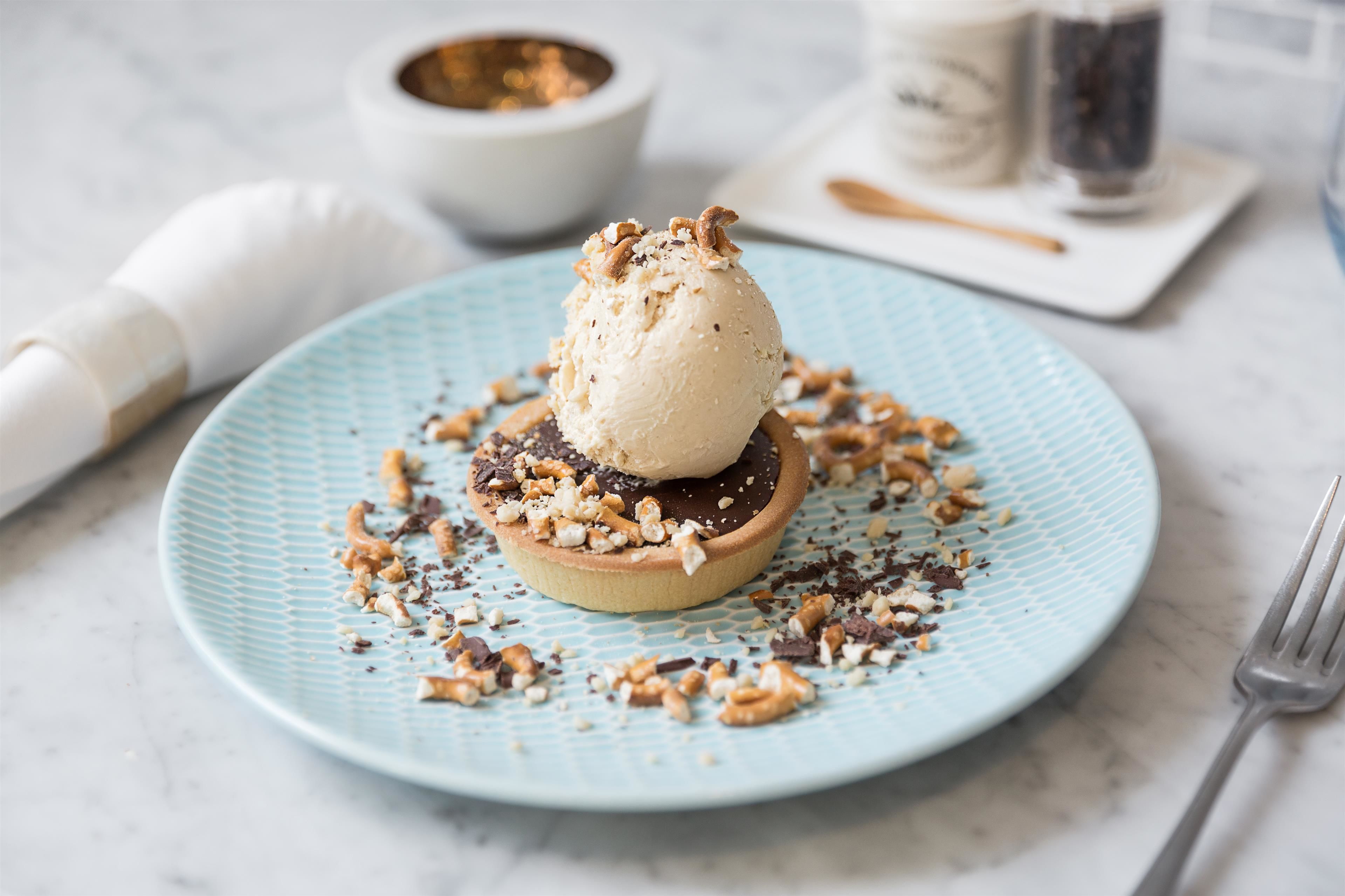 Dessert op een bord, met een deegroller en een zoutvaatje op de achtergrond.