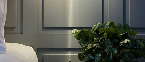 Una habitación moderna con una cama, una lámpara de pared y una planta en maceta.
