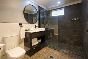 A modern bathroom with a toilet, sink, and shower. - Country Comfort Armidale (Armidale)