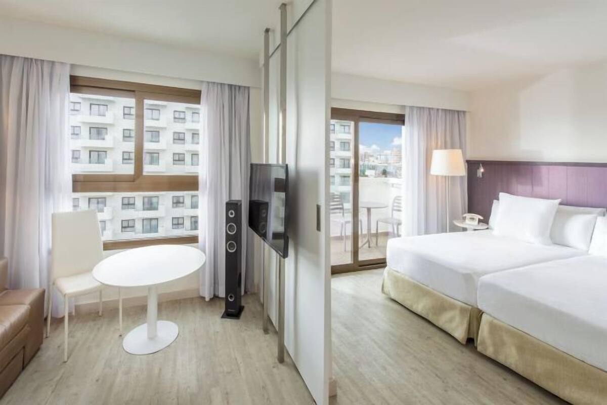 Une chambre d’hôtel avec un lit, une télévision, une table et une chaise.