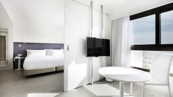 Een moderne hotelkamer met een bed, een televisie, een ronde tafel en een stoel.