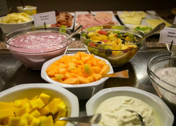 A buffet with various food items including fruit, yogurt, and other dishes. - Hotel Alarun Munich by Mayburgh (Unterschleissheim)
