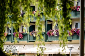 A building with balconies adorned with colorful flowers and white canopies.