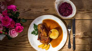 A plate with roasted meat, potatoes, and gravy, accompanied by a bowl of red cabbage.