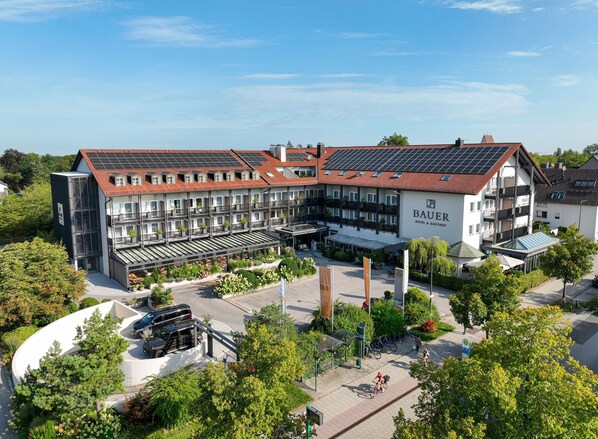 A hotel with multiple floors, balconies, and a solar panel roof.