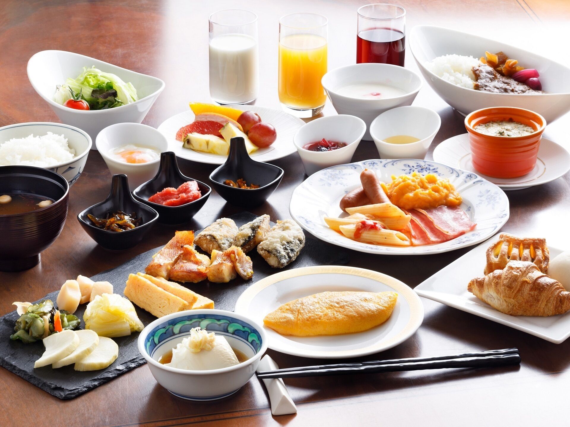 Diversos platos japoneses, como sushi, sashimi y tempura, dispuestos sobre una mesa de madera.