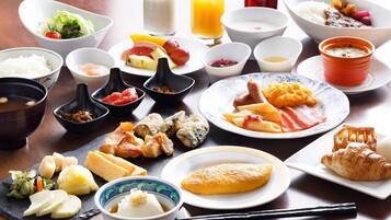 Diversos platos japoneses, como sushi, sashimi y tempura, dispuestos sobre una mesa de madera.