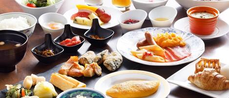 Diversos platos japoneses, como sushi, sashimi y tempura, dispuestos sobre una mesa de madera.