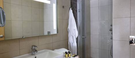 Un baño con lavamanos, espejo y ducha.