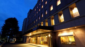 Un hôtel à plusieurs étages, doté d’une façade moderne, de grandes fenêtres et d’un espace d’entrée abrité.