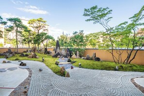 A landscaped garden with a pebble path, rocks, and trees. - The Saihokukan Hotel (Nagano)