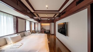Une chambre d’hôtel avec un grand lit, un bureau et une télévision.