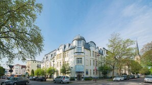 A historic hotel with a prominent dome and corner turret, situated on a tree-lined street. - Best Western Hotel Geheimer Rat (Magdeburg)