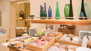 A buffet with various food items and decorative glassware. - Best Western Hotel Geheimer Rat (Magdeburg)