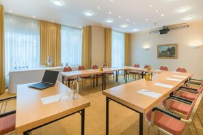 A conference room with long tables, chairs, a laptop, and a projector on the ceiling. - Best Western Hotel Geheimer Rat (Magdeburg)