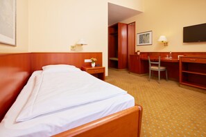 A hotel room with a bed, a desk, a chair, a television, and a wardrobe. - Best Western Hotel Geheimer Rat (Magdeburg)