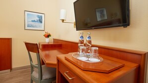 A hotel room with a wooden desk, a chair, a television mounted on the wall, and a framed picture on the wall. - Best Western Hotel Geheimer Rat (Magdeburg)
