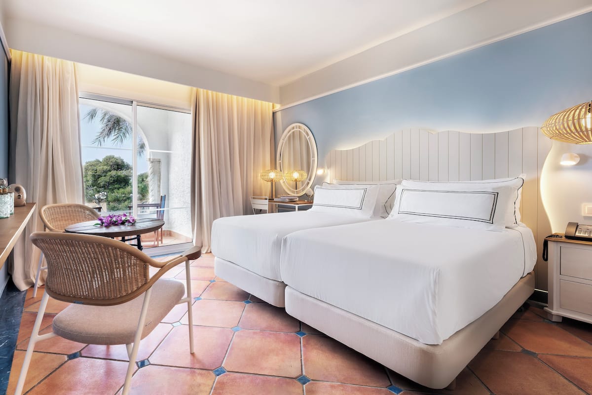 Ein Hotelzimmer mit Bett, Stuhl, Tisch und Lampe.