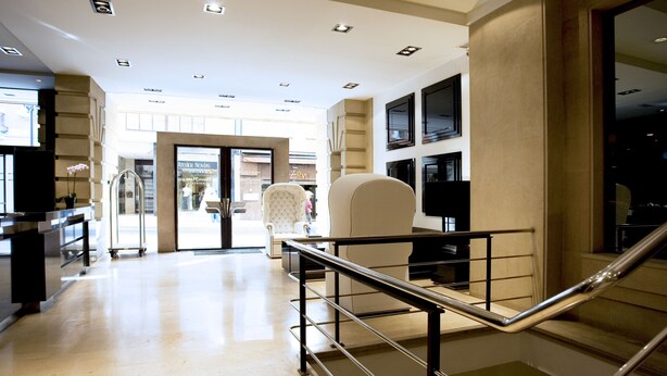 Eine Hotelhalle im modernen Design, mit einem großzügigen Bereich, einer Sitzecke und einer Treppe.