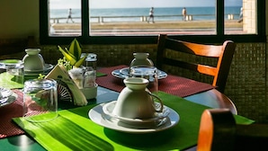 Una mesa con vistas a la playa a través de una ventana.